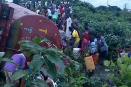PHOTOS: Nigerians Risk Their Lives Just to Scoop Fuel From A Tanker Rammed into Police Van in Uyo